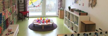Das Braune Zimmer mit Tischkicker, Tischbillard, rundem Esstisch und Regalen