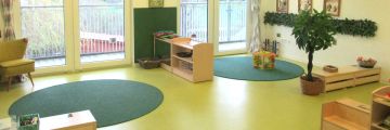 Das Grüne Zimmer mit blauen Teppichen und Spielzeug